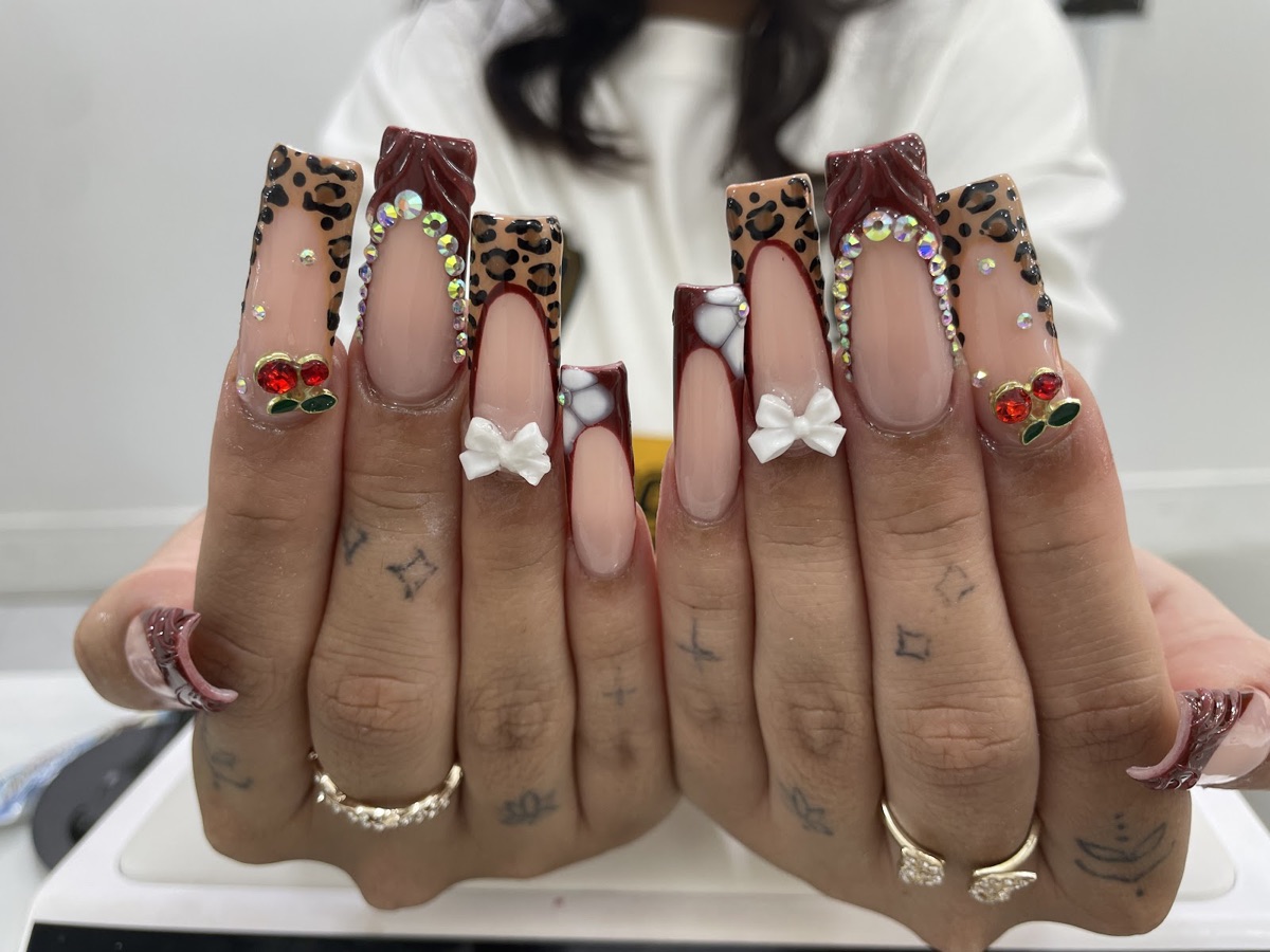 Long coffin nails with leopard-print French tips, rhinestones, 3D bows and cherry charms