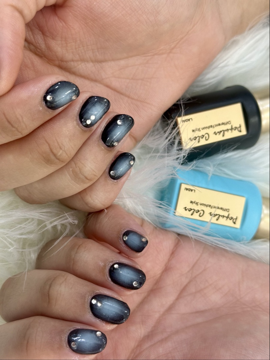 Midnight navy cat-eye gel nails photographed beside the magnetic polish bottle